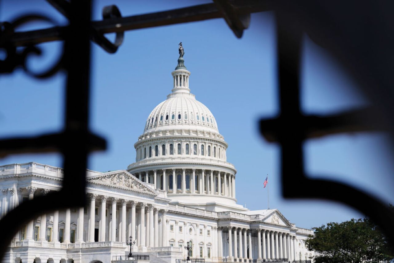 US Capitol Building in background with black metal fencing that surrounds the capitol dome in the foreground.