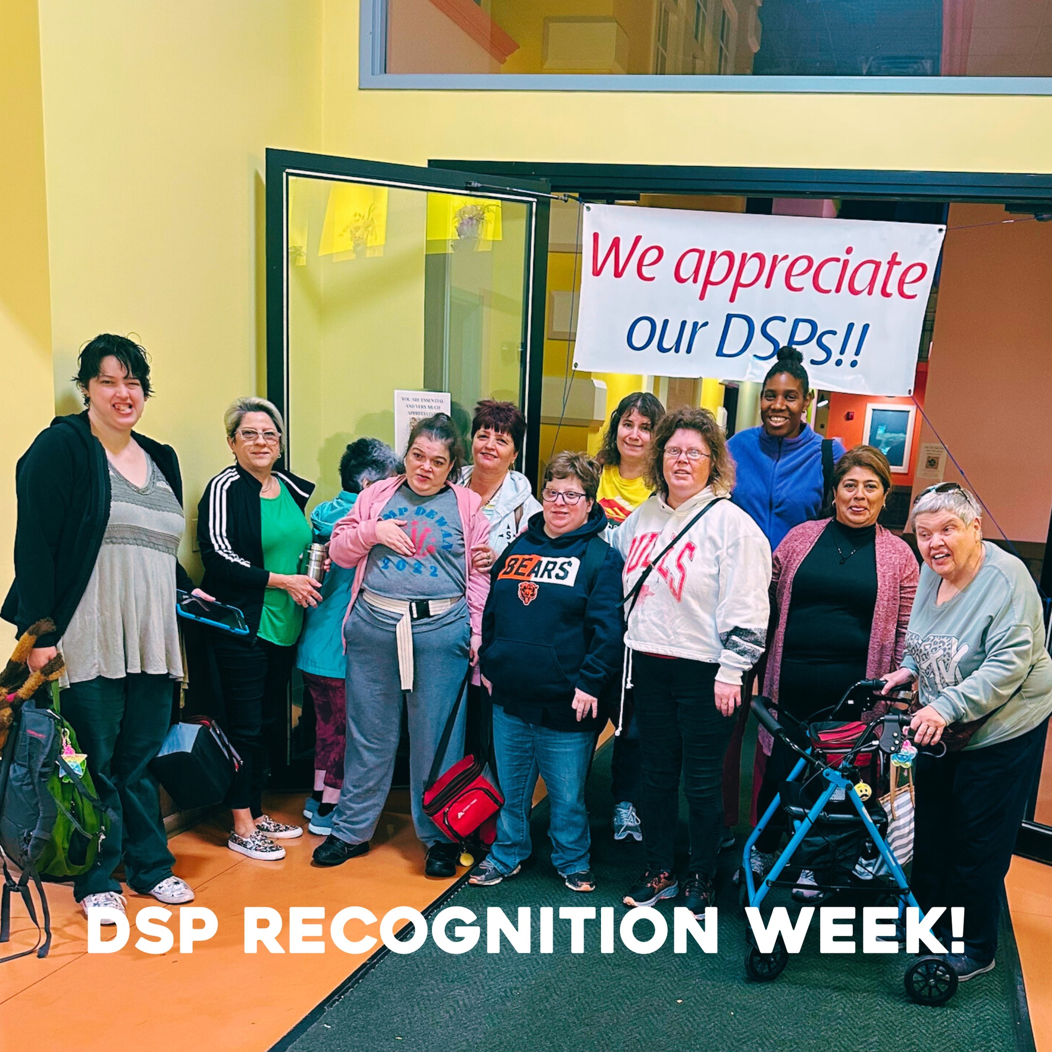 A DSP and people supported smiling in front of a banner that reads