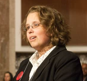 Nicole LeBlanc at a podium addressing an audience