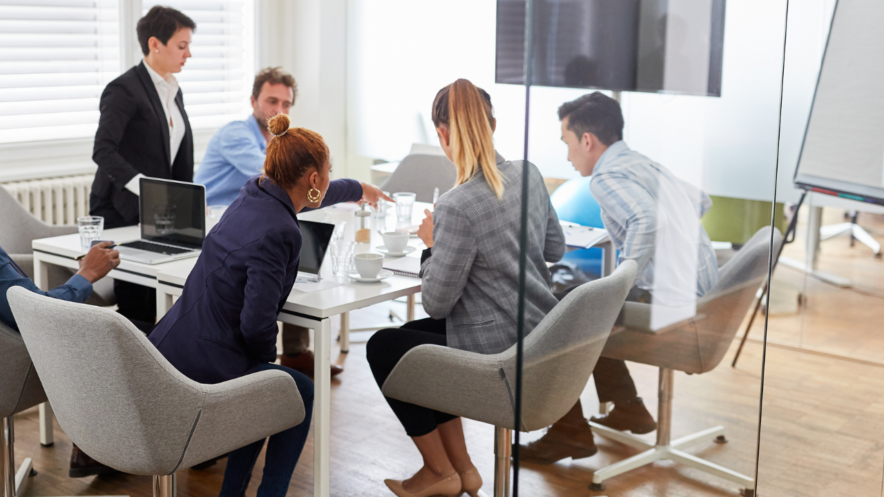 Team members collaborating around a board room table