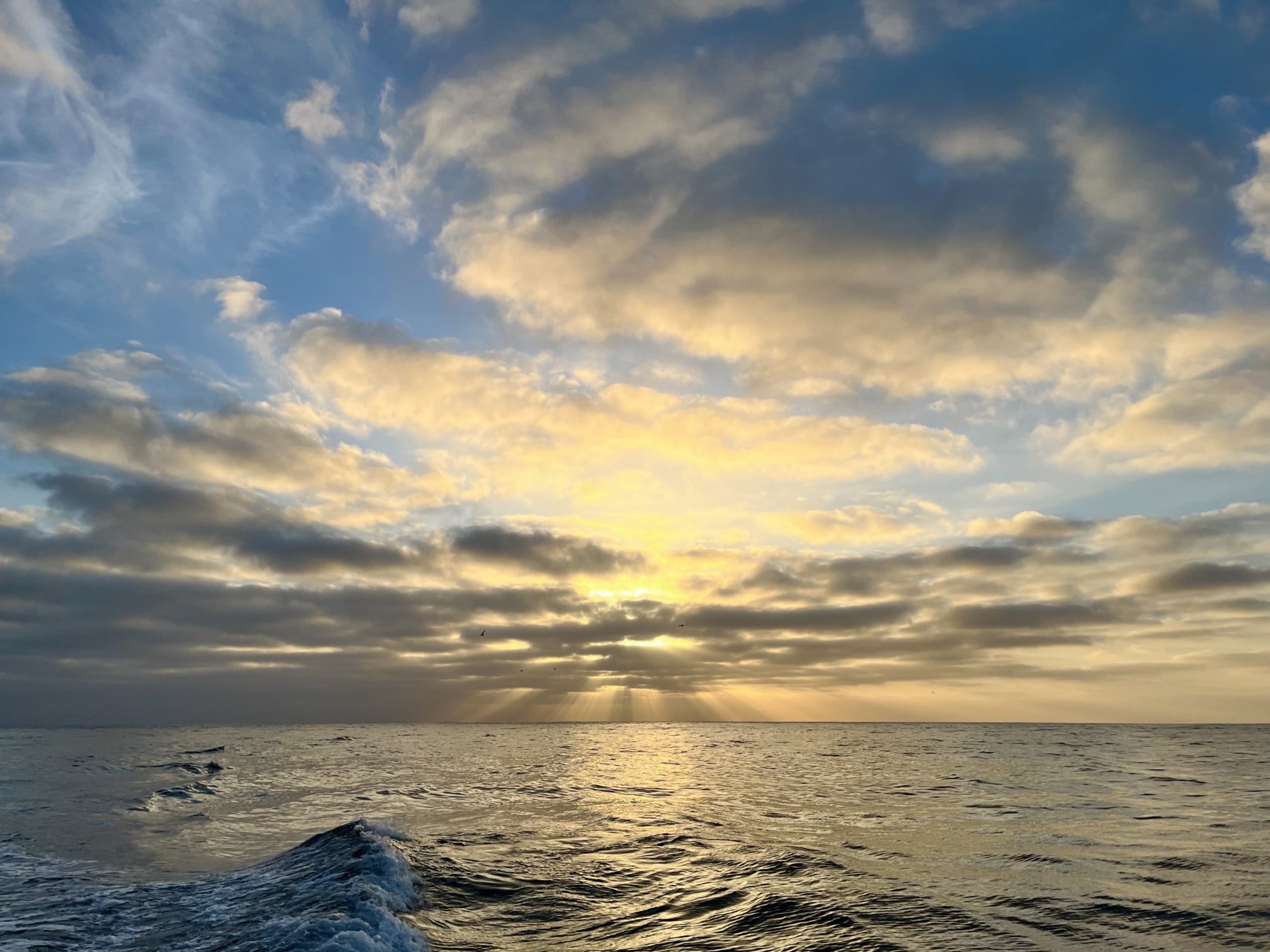 the sun setting on the horizon over the ocean
