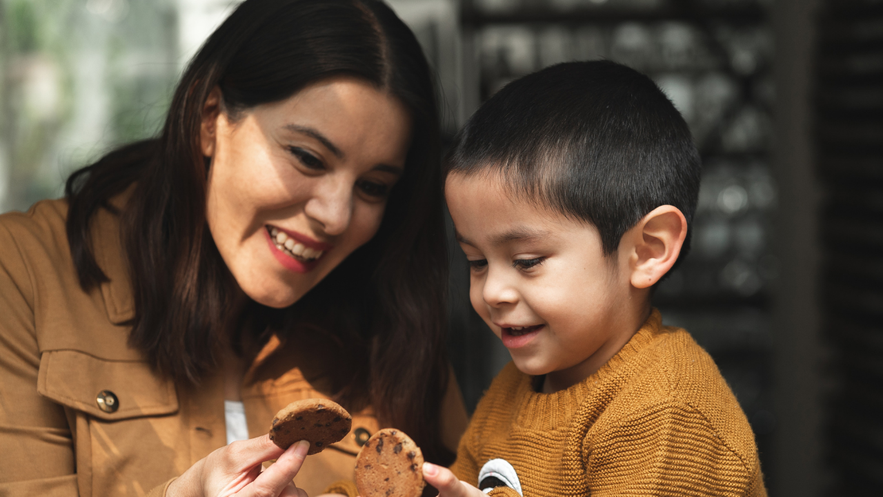 Stock photo of a women and her son each holding a cookie and smiling