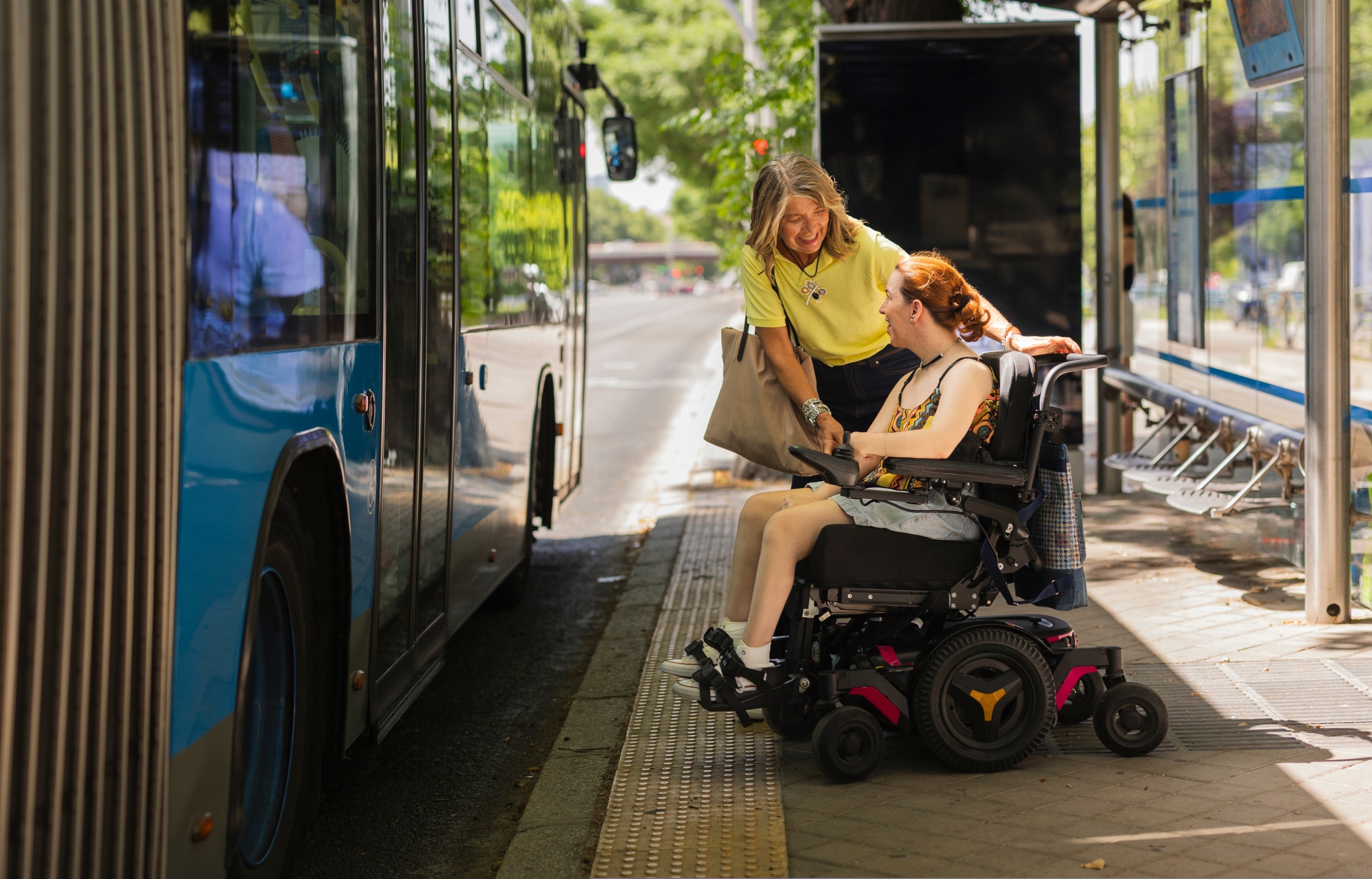 a DSP and person using a motorized wheelchair next to a public transit bus