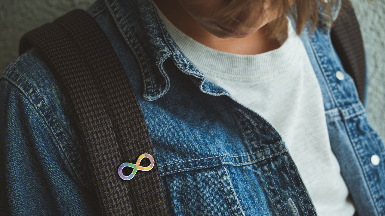 stock photo with person wearing a denim jacket with a Disability Pride Month pin