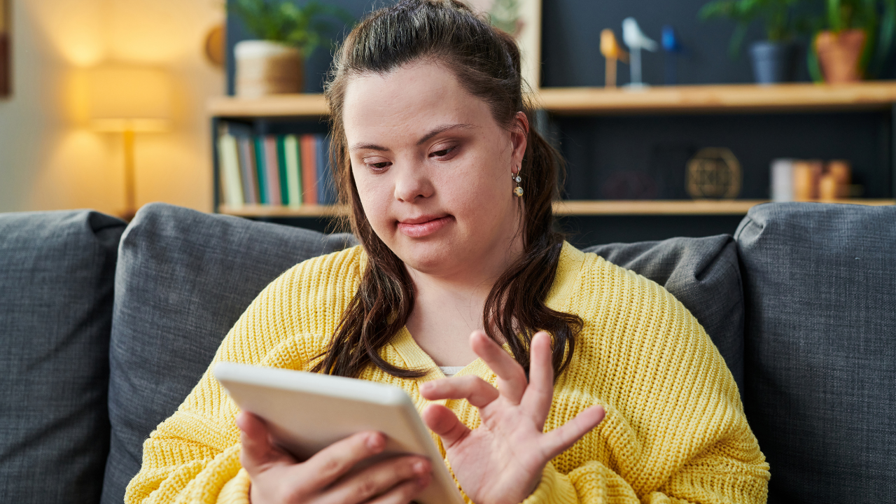 a woman with I/DD uses a tablet in her home