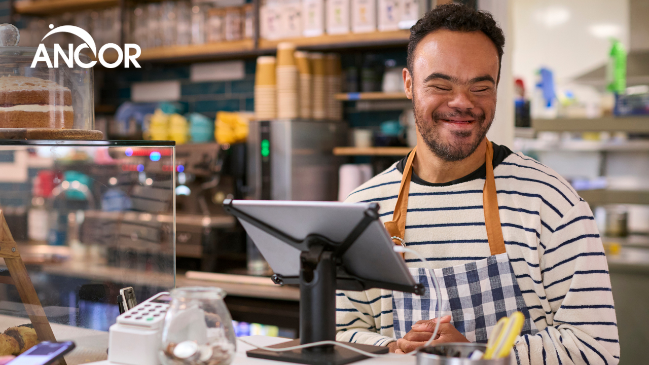 a person with I/DD works at a coffee shop counter