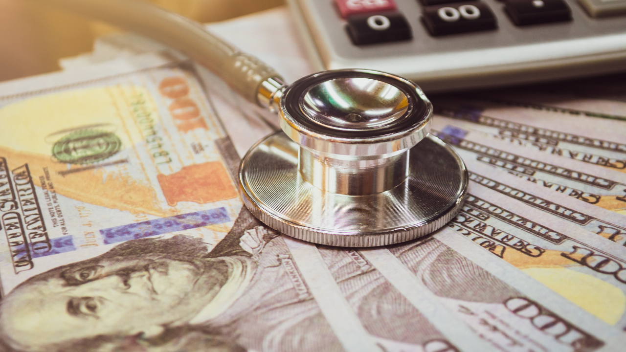 stock photo of stethoscope on hundred dollar bills